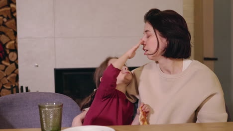 mother and daughter enjoying pizza dinner