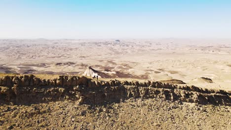 aerial towards ridge line in the negev desert located in israel with two hikers standing