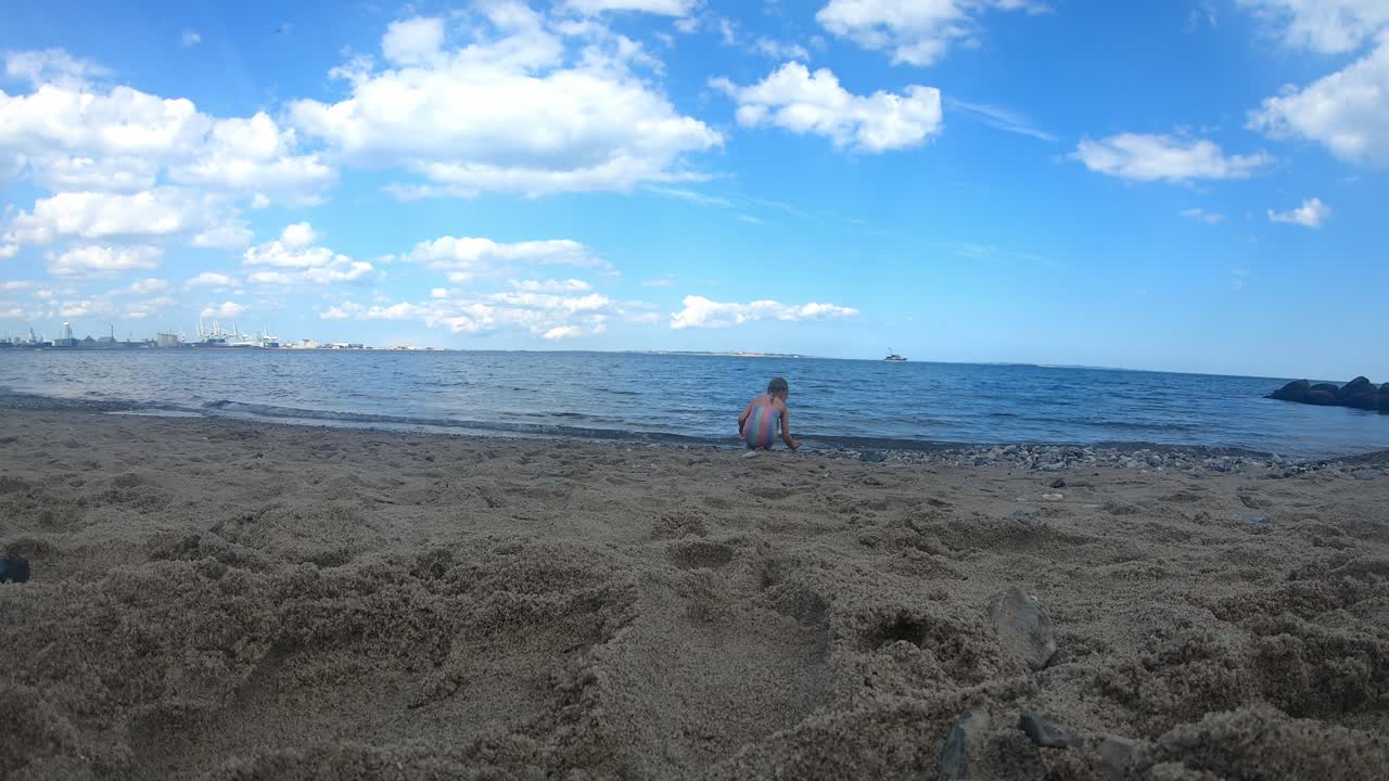 수영복을 입은 7살 소녀가 아르후스 덴마크의 마르셀리스보르그 해변에서 혼자 놀고 있습니다.