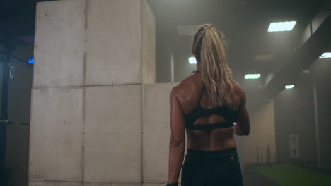 fatigue and exhaustion. a strong woman is breathing heavily and recuperating after cross training. perspiring drops of sweat.
