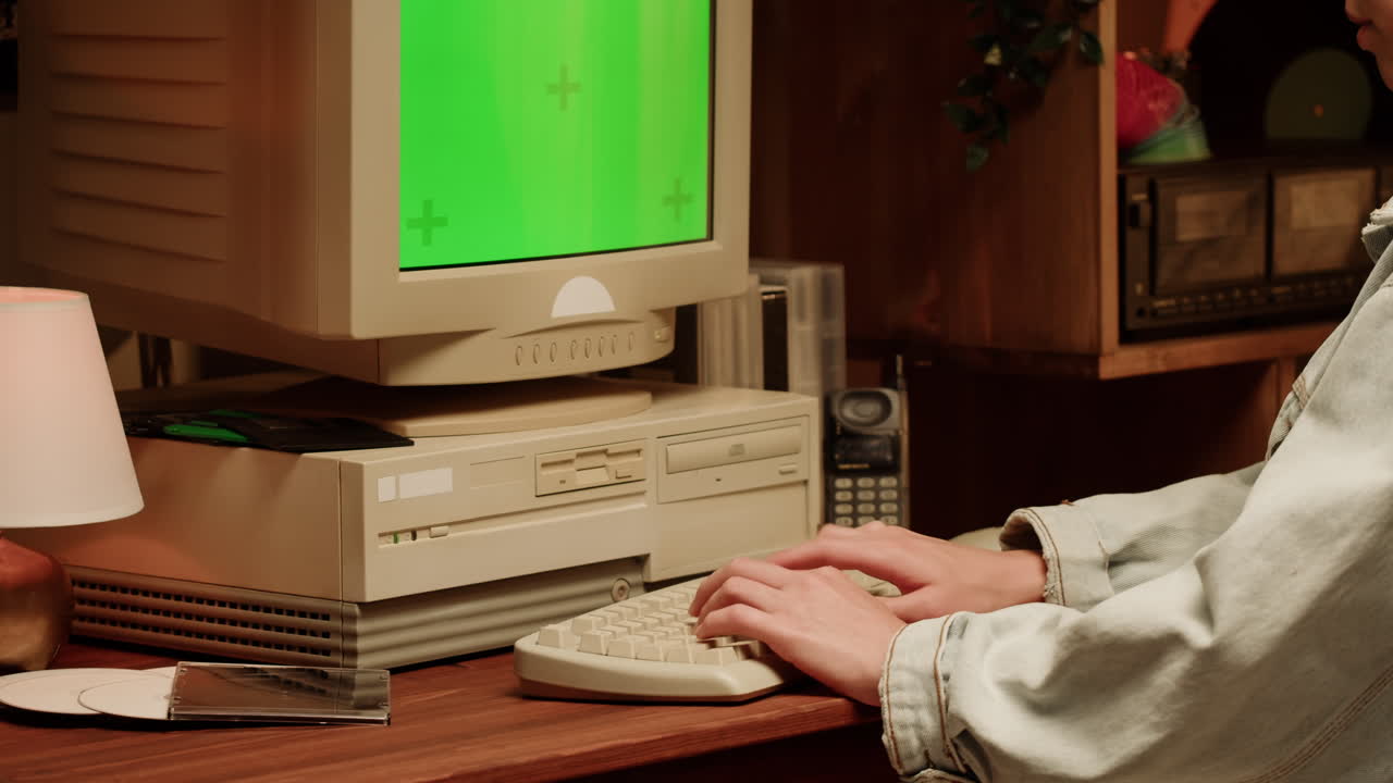 Person Typing on a Vintage Computer with Green Screen