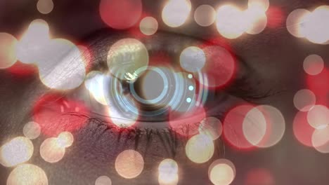 pink glowing spots of light against round scanner over close up of female eye