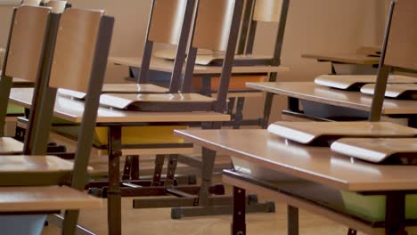 shot of an abandoned row of tables and chairs in an empty classroom during a pandemic