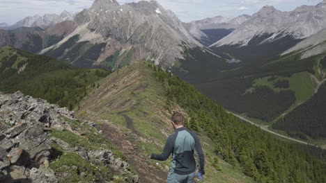 caminante caminando por la cresta con carreteras distantes rockies kananaskis alberta canada