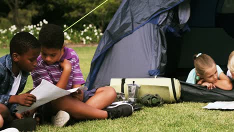 group of children reading map in park