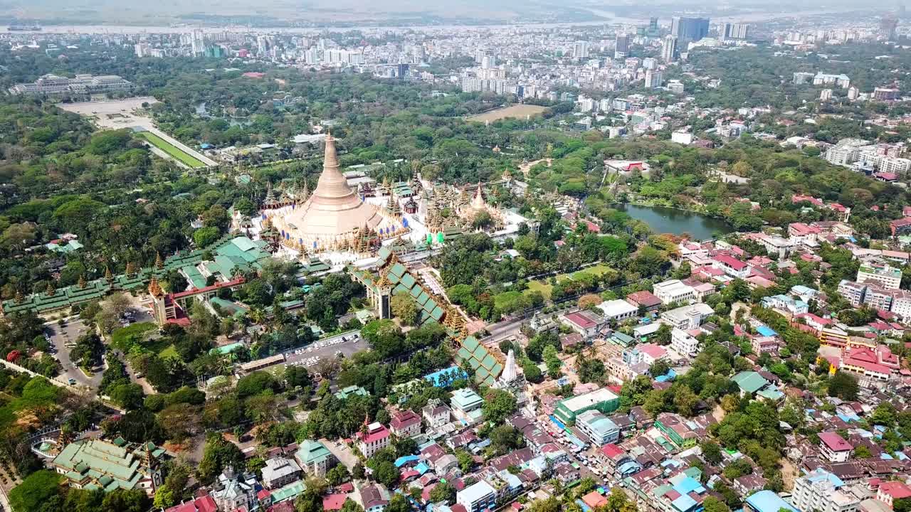 미마의 랭곤 (rangoon) 에서 풍요로운 초록색과 도시 개발로 둘러싸인 웅장한 황금 스투파인 슈데가곤 파고다 (shwedagon pagoda) 를 드론으로 촬영하여 종교와 현대 생활의 도시 혼합을 보여줍니다.