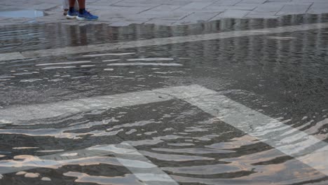 Child-in-green-clothing-plays-in-flooded-Piazza-San-Marco,-Venice,-Italy