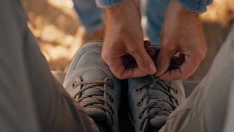 person tying shoelaces on hiking boots