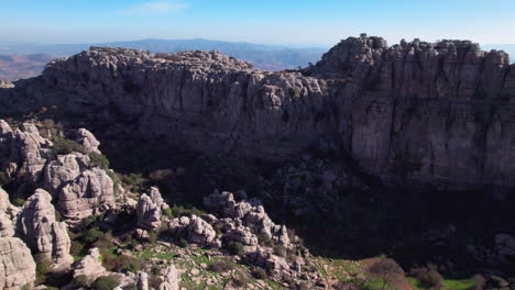 Toma-Aérea-Con-Plataforma-Rodante-De-La-Reserva-Natural-De-El-Torcal-De-Antequera,-Málaga,-Andalucía,-España,-Que-Revela-El-Pueblo-Cercano-Y-El-Paisaje-En-Un-Día-Despejado.