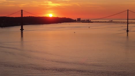 establecimiento aéreo de la silueta del puente colgante con el cielo de neblina naranja roja al atardecer
