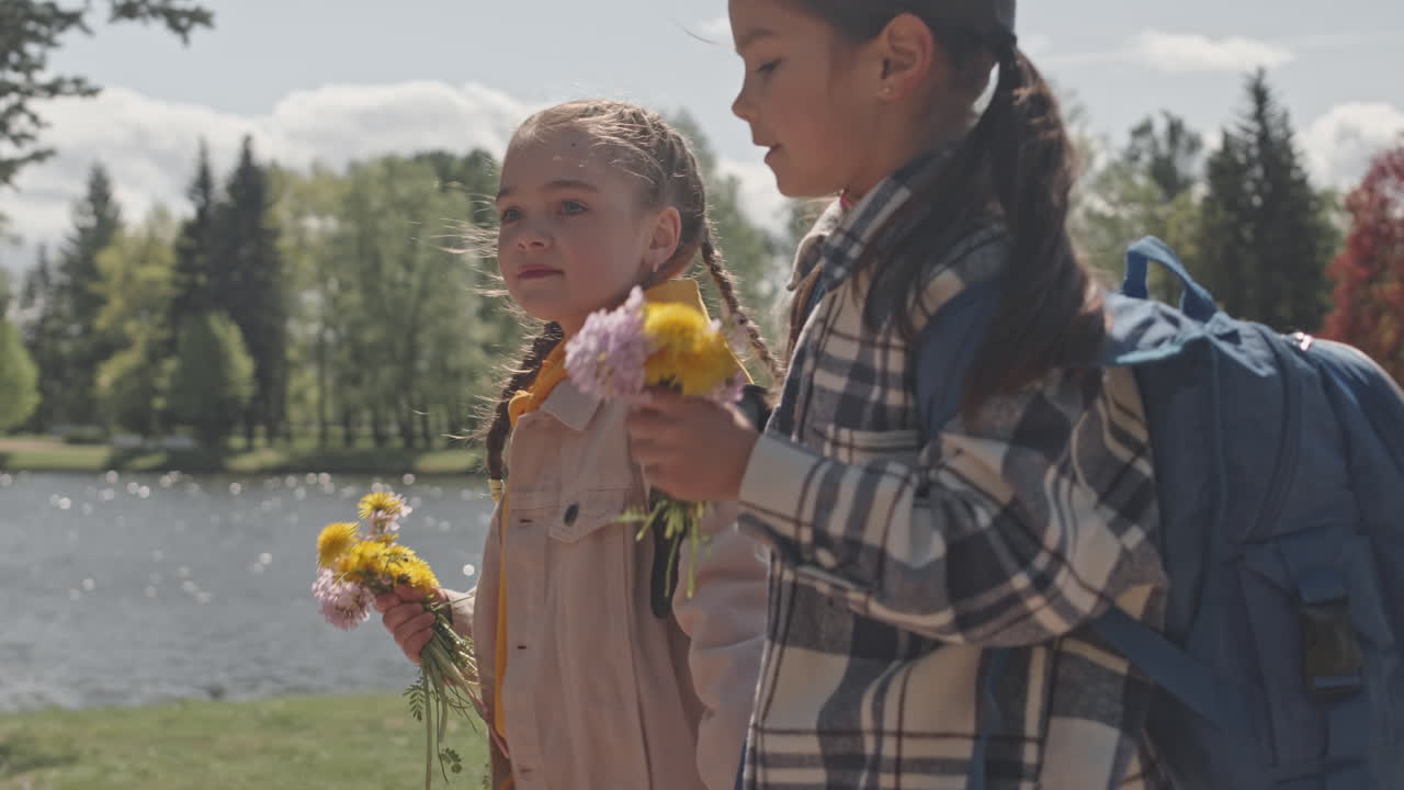 Two Girls Walking in a Park with Flowers