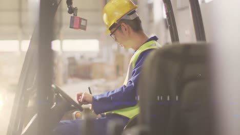 animation of glowing light over asian man working in warehouse