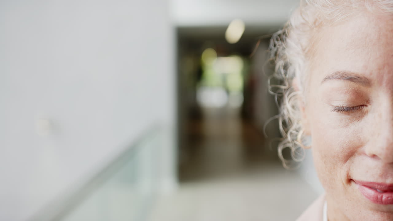Donna sorridente con gli occhi chiusi, concentrata sul relax e sulla consapevolezza, spazio per il testo