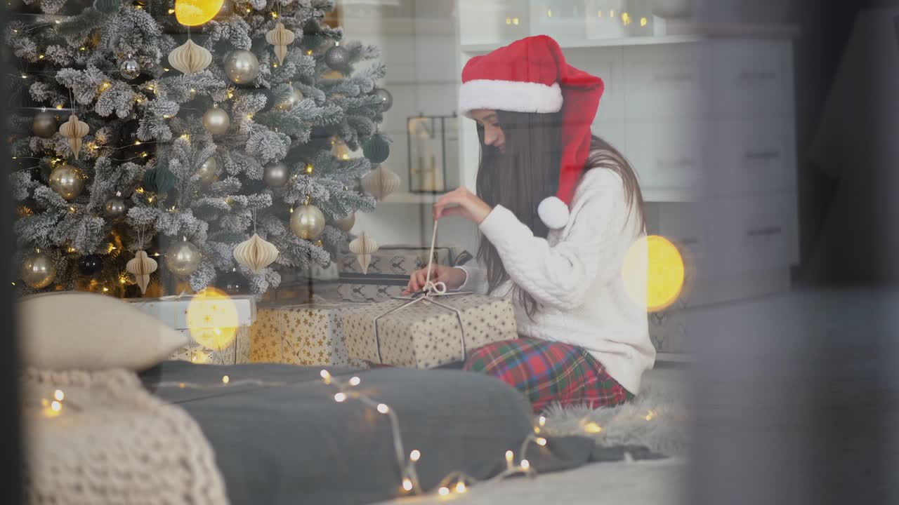 mujer abriendo regalos de navidad junto al árbol de navidad