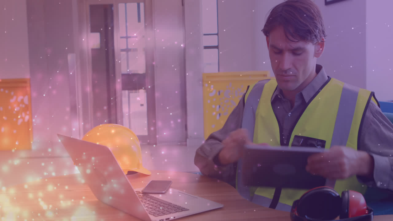 анимация светящихся пятен над кавказским мужчиной-инженером с помощью ноутбука и планшета