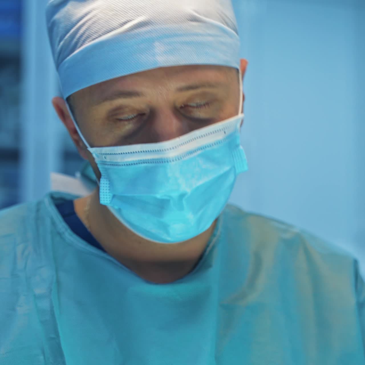 Portrait of a doctor. Professional surgeon in medical cap and mask performing a plastic surgery in the hospital. Medical concept.