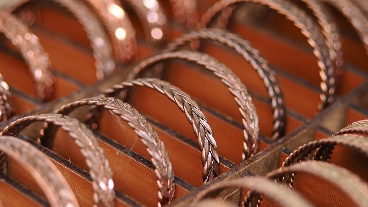 Primo piano di braccialetti di rame fatti a mano esposti in file