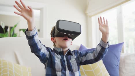 caucasian boy waving hands and talking during playing with vr headset