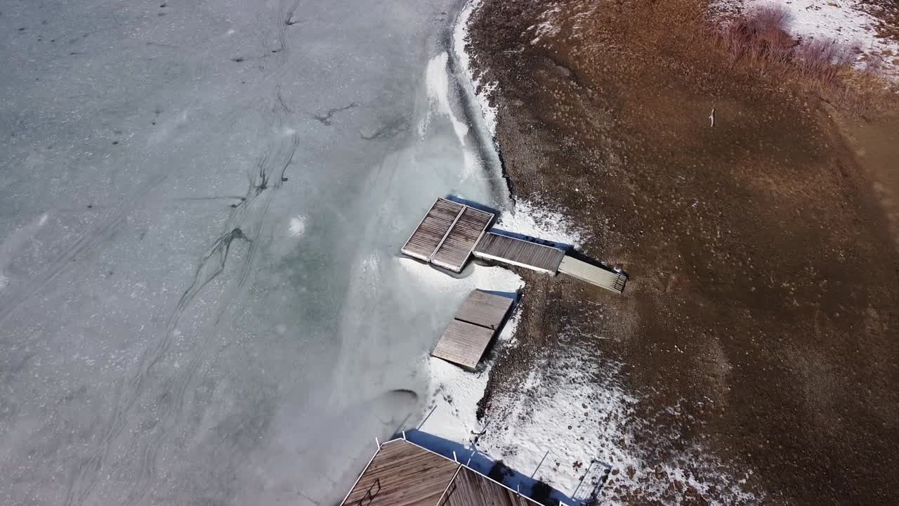 모래 해변 위를 날고 호수에 얼어붙은 보트 선착장