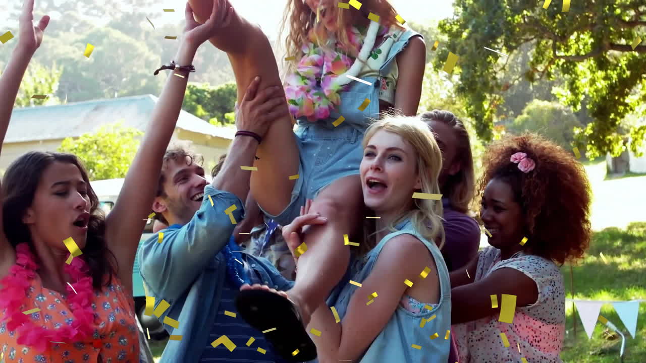 celebrando con animación de confeti sobre amigos levantando a una persona al aire libre
