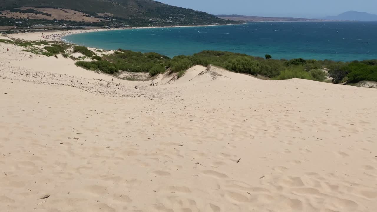 Slow tilt up reveal of the dune of Valdevaqueros with Gibraltar in the horizon.
