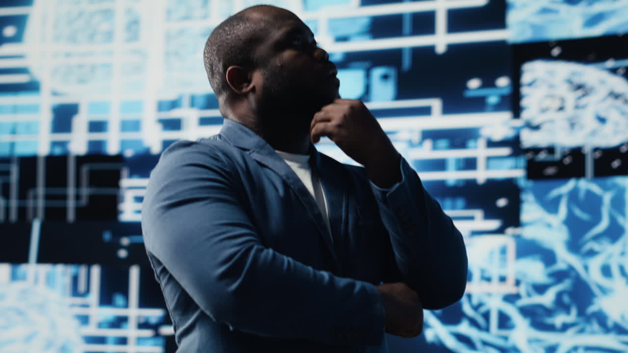 Black IT professional coding for futuristic AI brain blueprints in background
