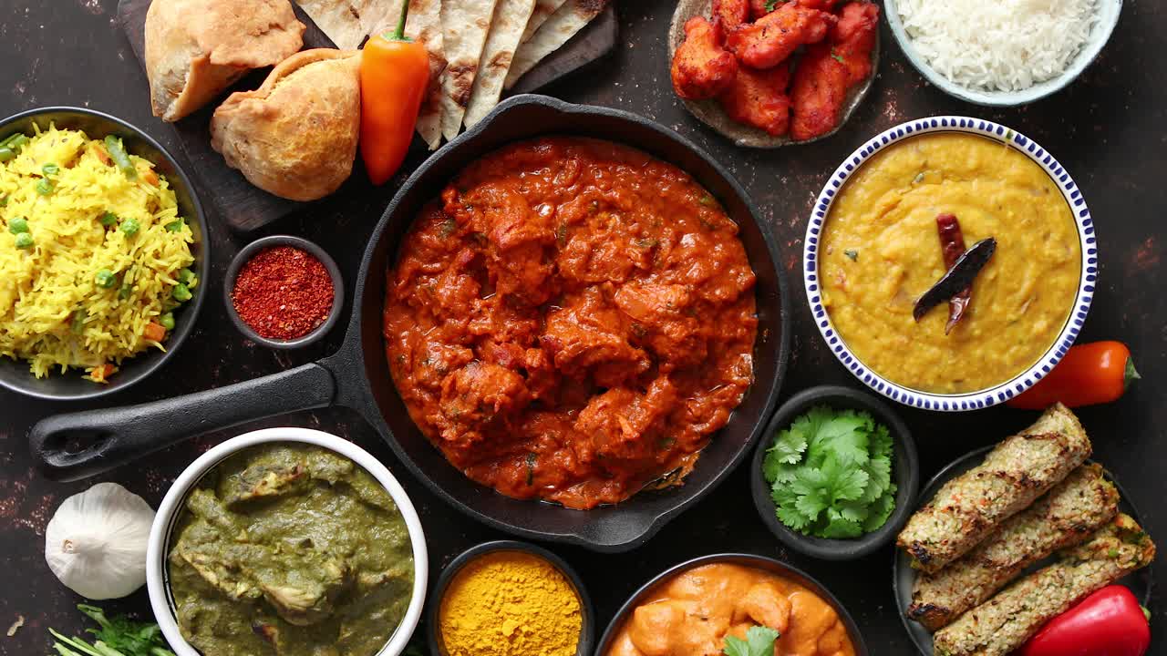 Vari piatti indiani su un tavolo. Piccante Chicken Tikka Masala in una padella di ferro.