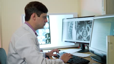 young male doctor working on computer. professional male doctor neurologist working with scans on computer