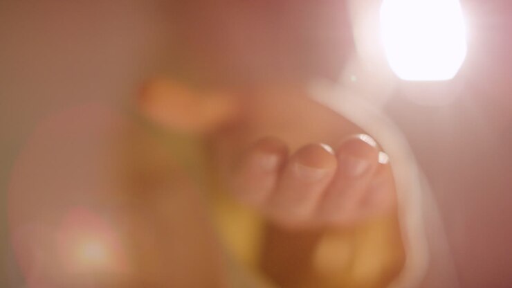 Backlit Shot Of Man With Long Hair And Beard Representing Figure Of Jesus Christ Extending Hand In Friendship Towards Camera