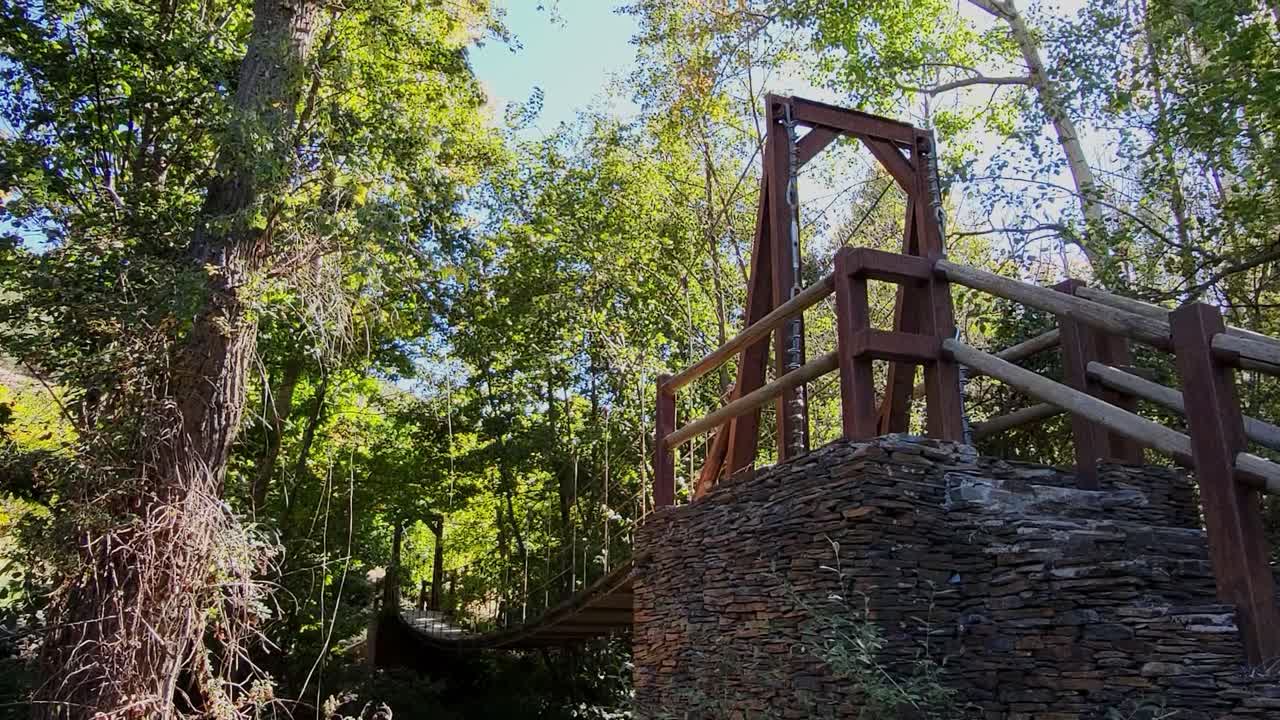 Ponte sospeso su un fiume, realizzato in pietra, legno, struttura metallica e cavi d'acciaio. Architettura, costruzione di ponti. Ingegneria dei ponti. Spagna