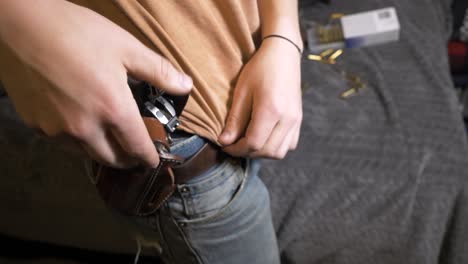 60p-slomo: sacando una pistola semiautomática de la funda de la cintura exterior de la cadera de cuero