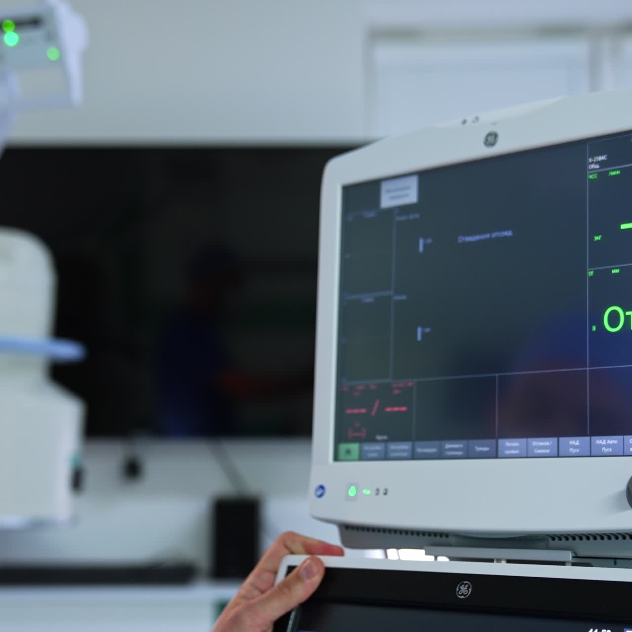 Doctor's hand turn the screens of lung ventilator system. The monitors are switched on and ready for usage. Blurred backdrop