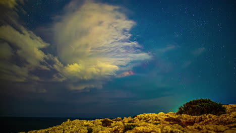 Milky-Way-galaxy-moving-across-night-sky-with-forming-cloudscape,-time-lapse-view