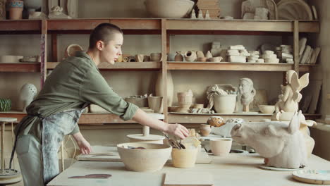 woman preparing tools for work in pottery studio