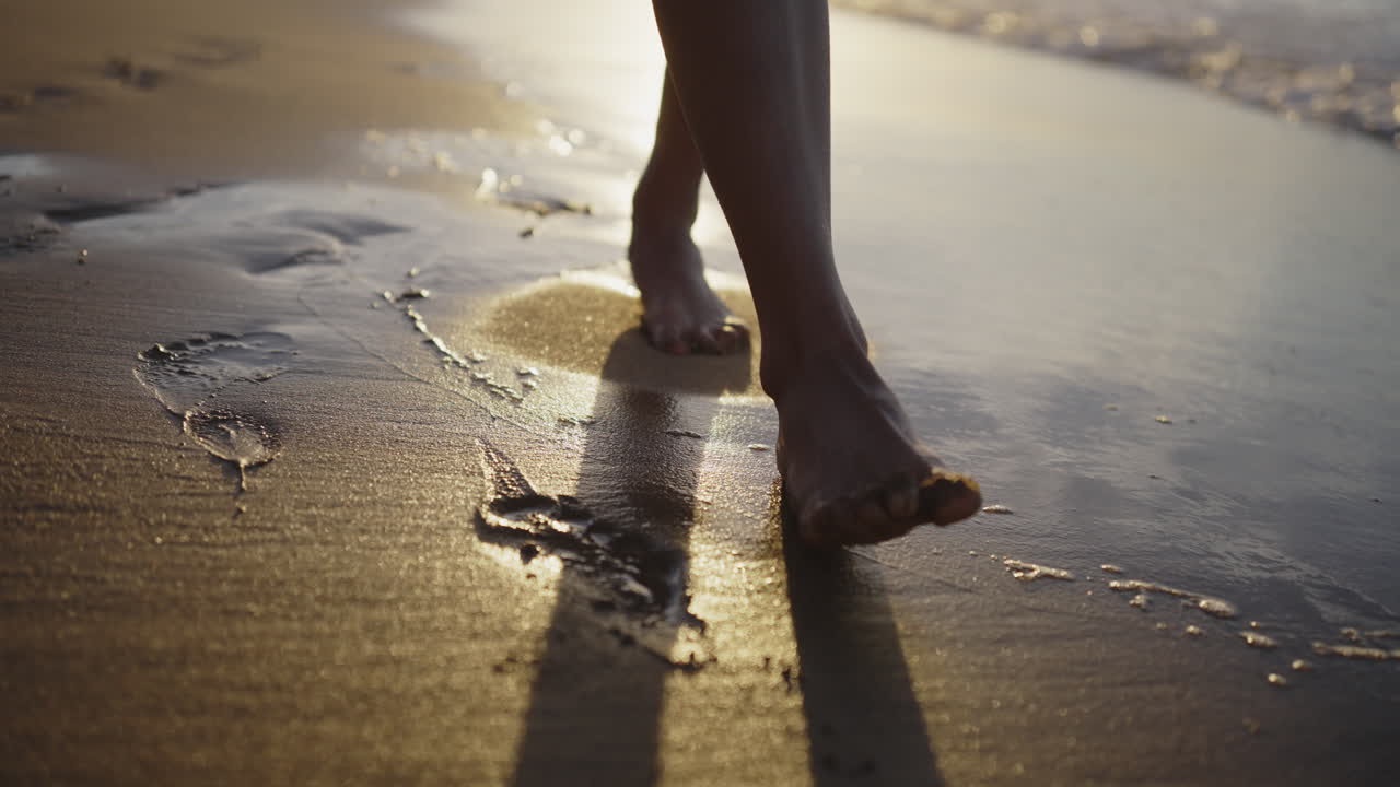 Passeggiata a piedi nudi sulla spiaggia al tramonto