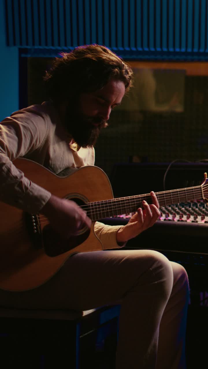 Uomo che suona la chitarra acustica in uno studio musicale professionale