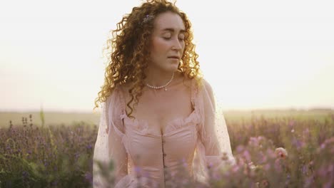 a woman with curly hair observes the beauty of a lavender field in bloom