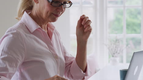 Mujer-Madura-En-Casa-Buscando-Información-Sobre-Medicamentos-En-Línea-Usando-Una-Computadora-Portátil