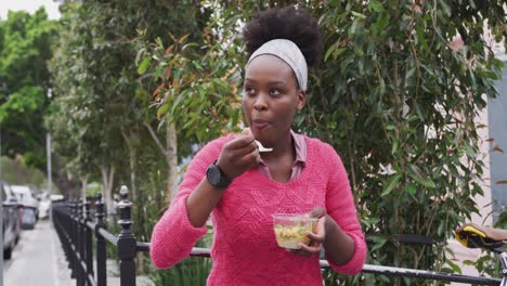 african american eating a salad in street