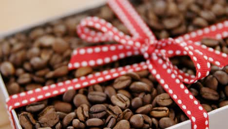 roasted coffee beans packed with ribbon in box