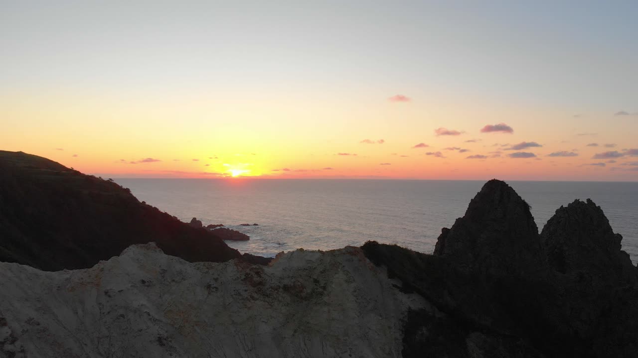vuelo de drones sobre un acantilado hacia la puesta de sol