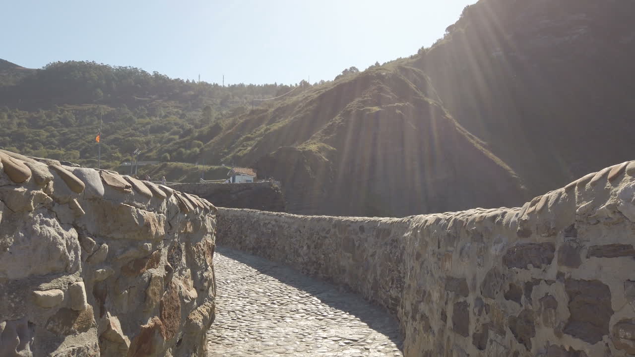 Woman walking on a stone pathway between walls