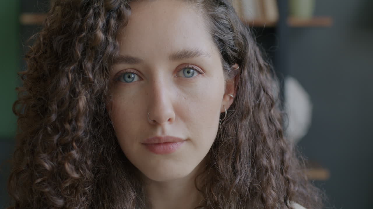 Close-up portrait of a woman with curly hair and blue eyes