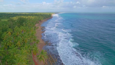 Schaumige-Wellen-Plätschern-Am-Sandstrand-Des-Tropischen-Strandes-In-Nagua,-Dominikanische-Republik---Drohnenaufnahme-Aus-Der-Luft