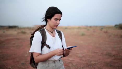 Woman-using-compass-in-desert