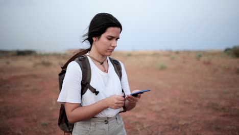 mujer usando brújula en el desierto