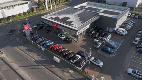 orbital aerial view of modern nissan dealership with vehicle display and parking area on slough trading estate in berkshire, uk, october 2024