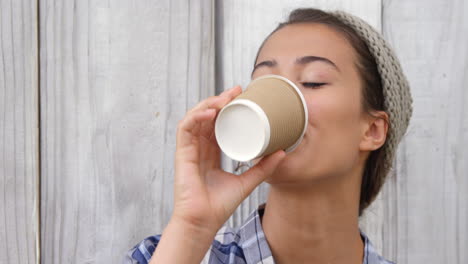 young woman having coffee from disposable cup