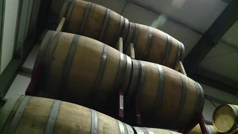 tilting shot of several wine barrels in storage