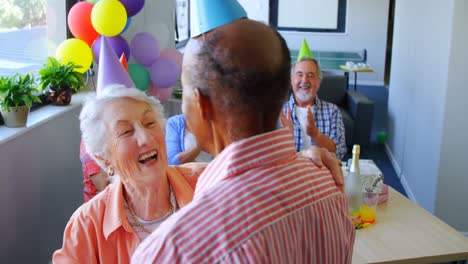 senior couple wearing party hats dancing at birthday party 4k